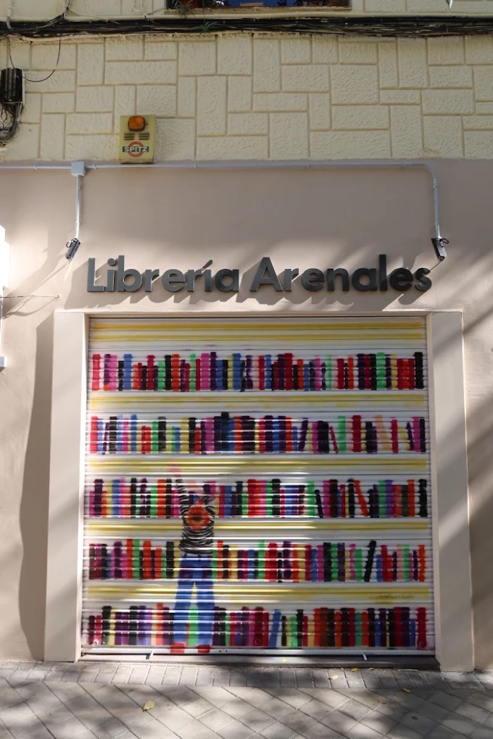 La cortina de Librería Arenales, pintada con lomos de libros de colores